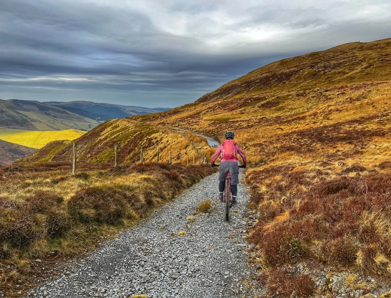 A person cycling a mountain bike high on a mountain.