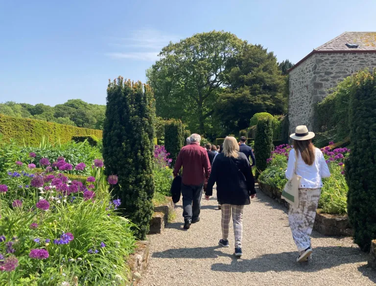 A group of people walking through a garden.