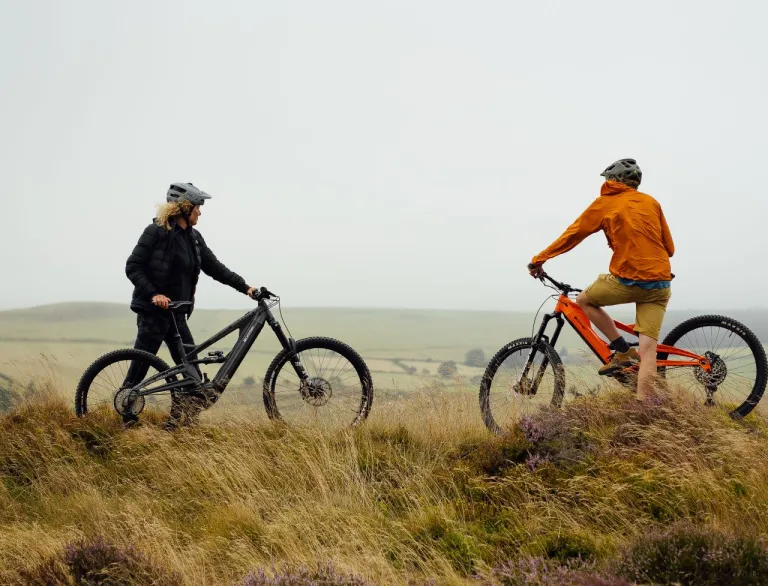 Two people of bikes overlooking the countryside.