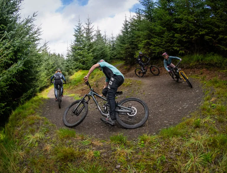 Group of bikers going down a mountain trail.