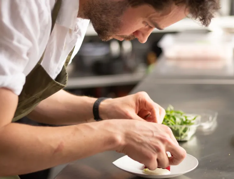 Chef Tom Waters plating food at Gorse.