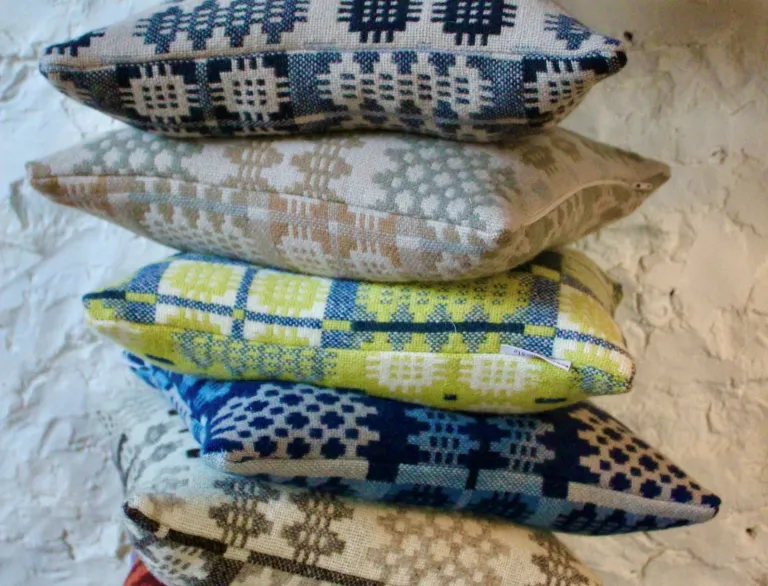 A stack of woven, colourful cusions.