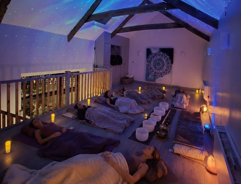 Women lying down relaxing in a darkened room.