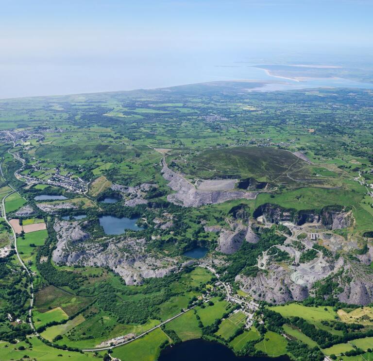 An aerial shot of a slate quarry valley, fields and reservoirs.