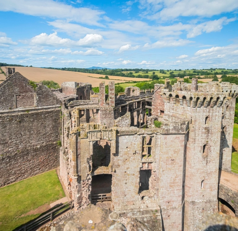 The ruins of a castle with views of the countryside beyond.