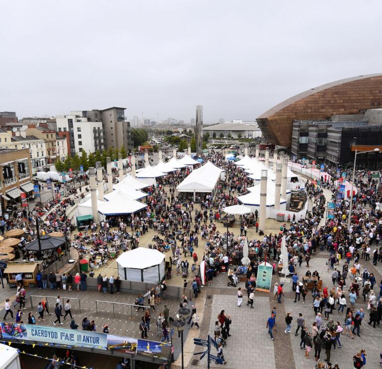Rows of stalls with crowds of people enjoying Cardiff Bay Food Festival.