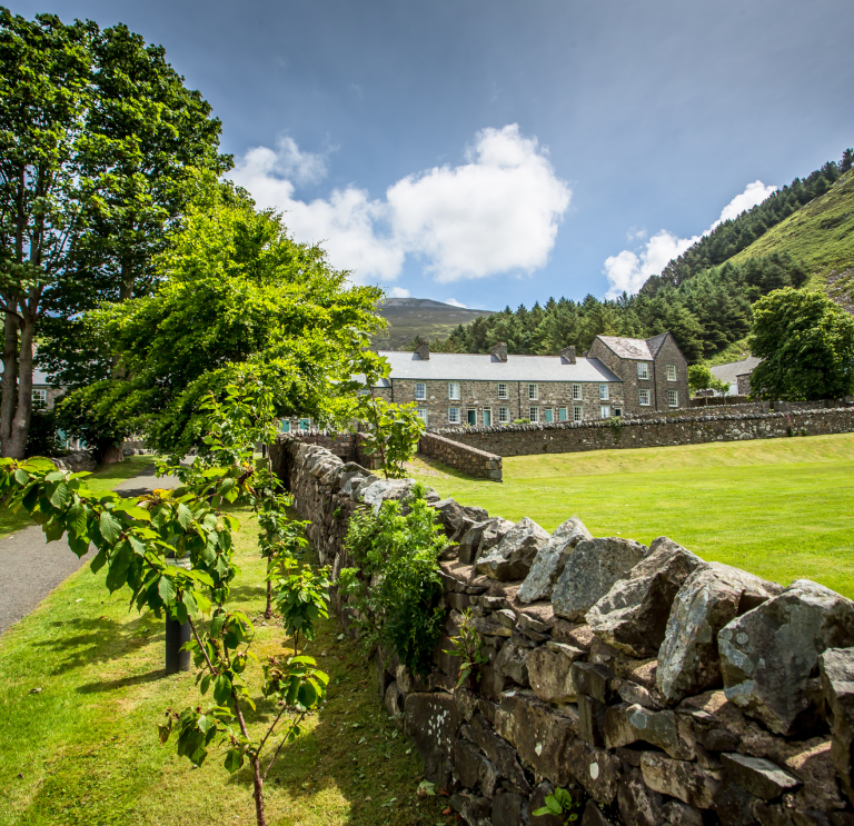 Stone built cottages at Nant Gwrtheyrn looking over the grass square.