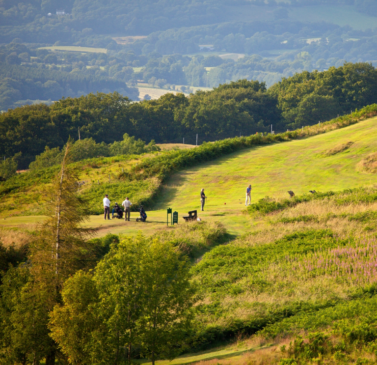 Golfers playing a round with stunning views seen from the height of the golf club.