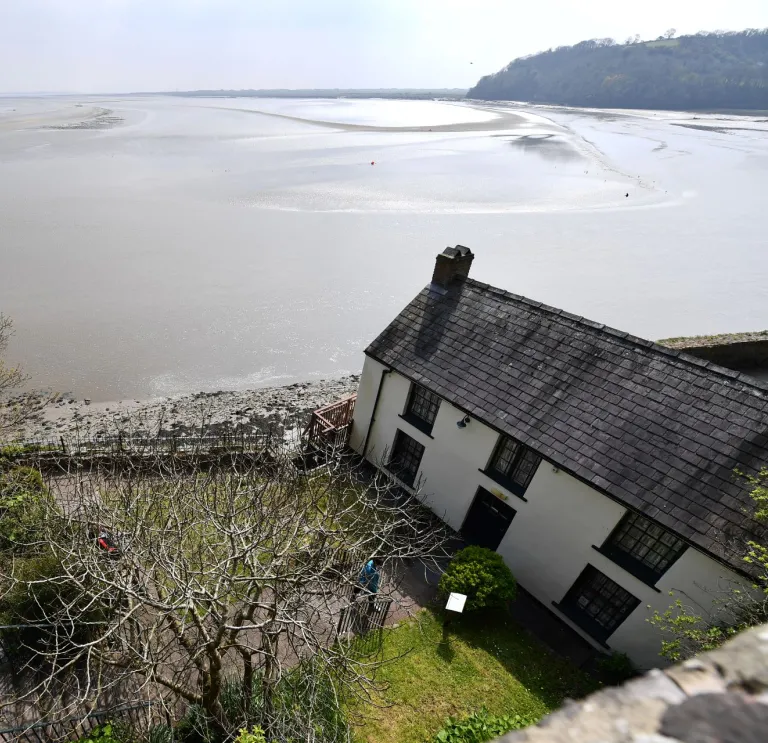 Views of a boathouse and the estuary beyond.