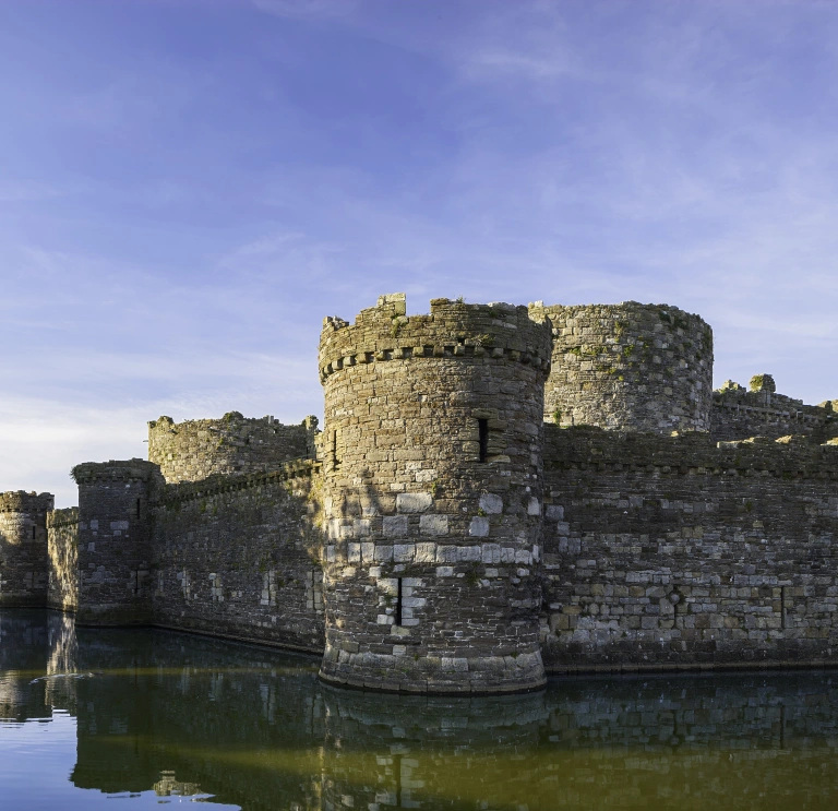 A castle surrounded by a moat on a sunny day.