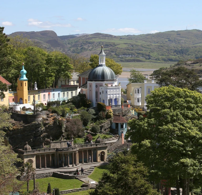 A view of Portmeirion village and gardens beyond the trees.