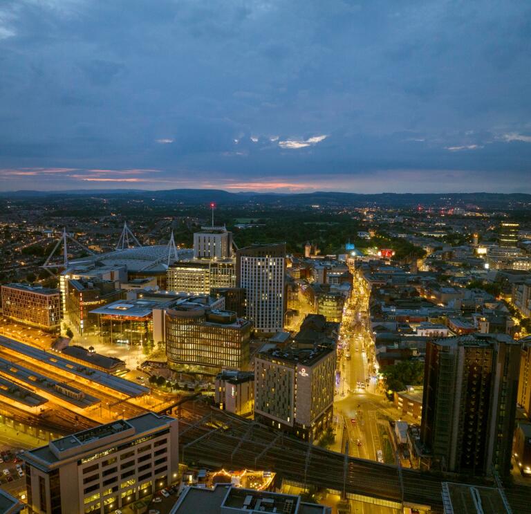 Aerial shot of a city centre lit up at night.