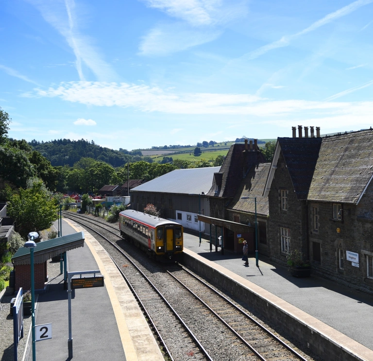 A train pulling into a station on a sunny day.