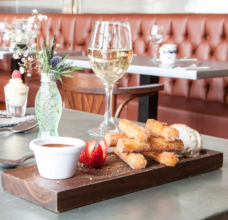 Desserts and wine on a table in a restaurant.