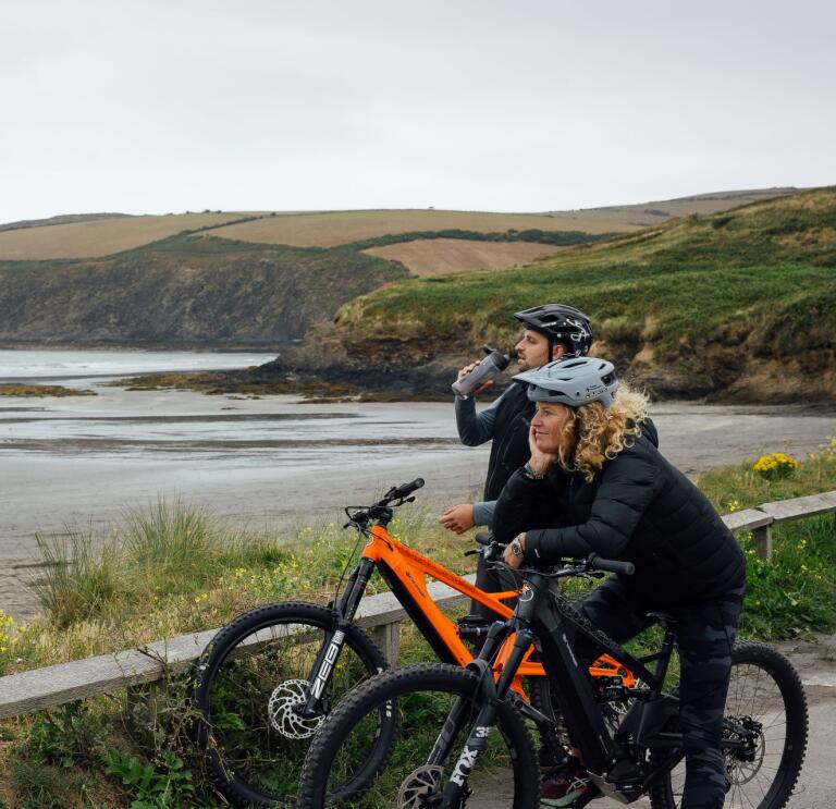 People on e-bikes looking out to the coast.
