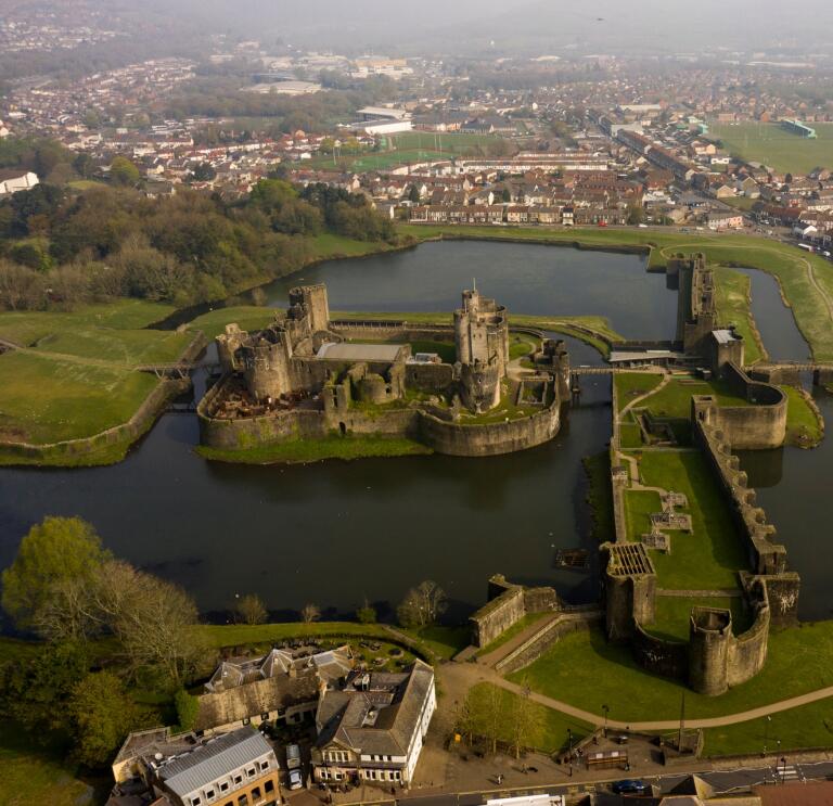 Aerial shot of a castle surrounded by a moat.