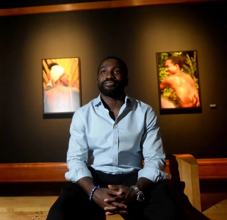A man sitting on a bench looking at an exhibition.