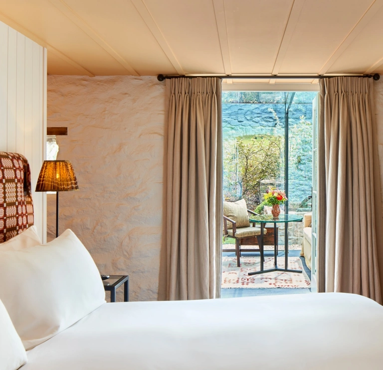 Bedroom suite leading out to a balcony with table and chairs.