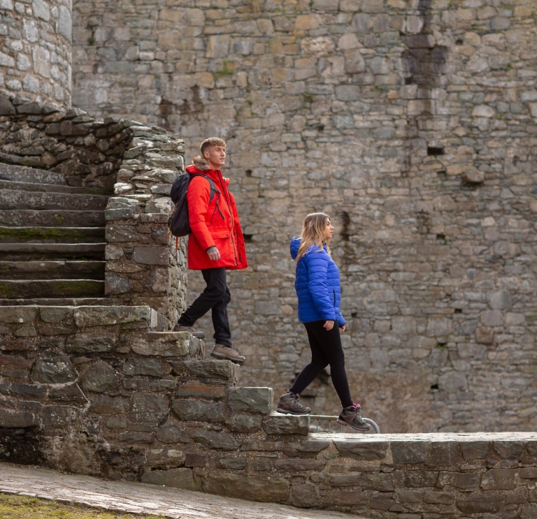 A couple walking down the steps in a castle.