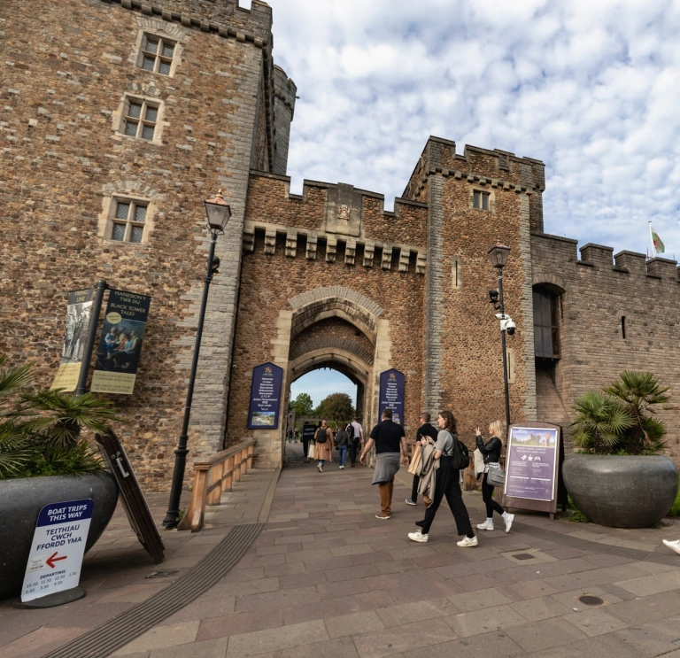 People walking into the entrance of a castle.