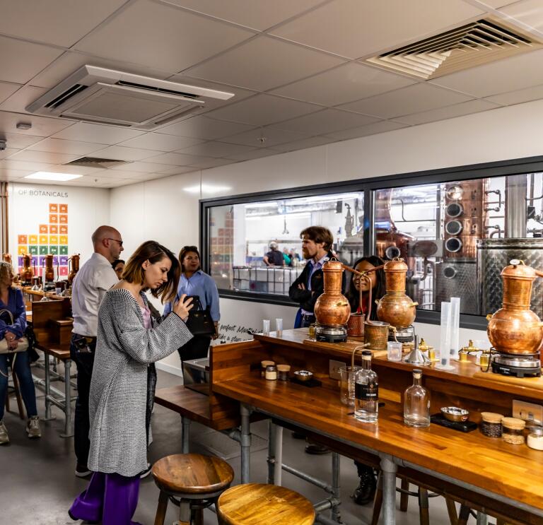 Group of people in a workshop at a gin making distillery.
