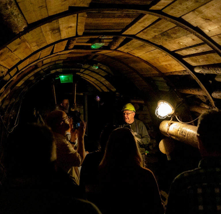 Group of people in an underground mine on an tour with a guide.