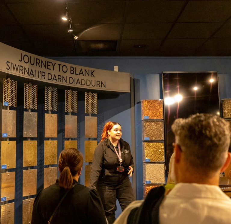 Group of people listening to a tour guide at The Royal Mint.