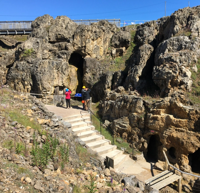 People looking at the rocks near the entrance to an underground mine.