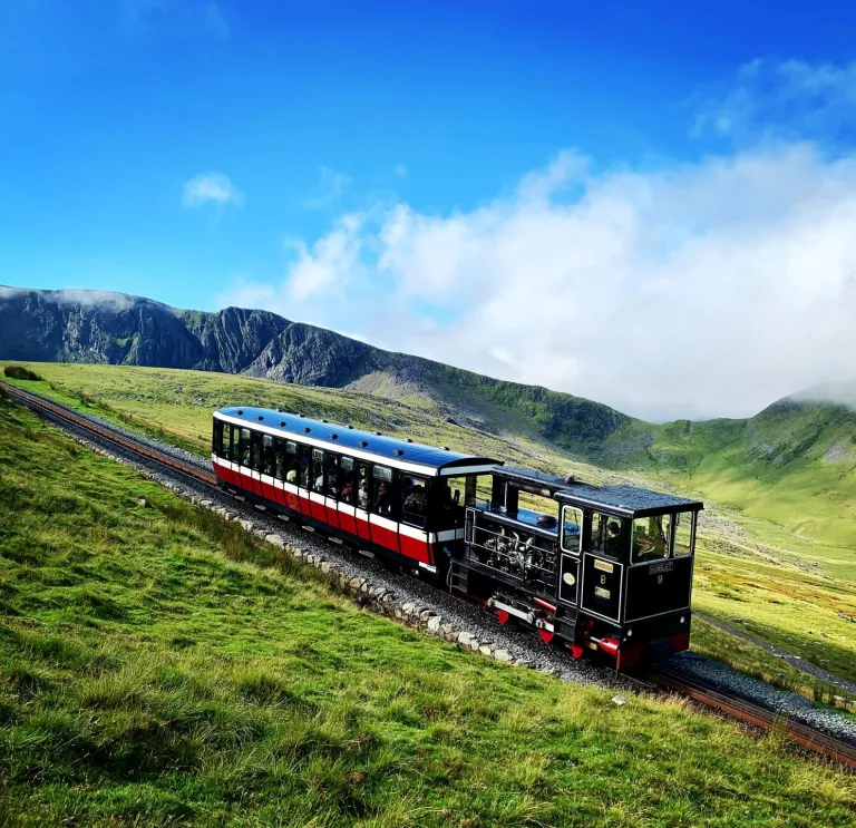 A steam train going up a mountain.