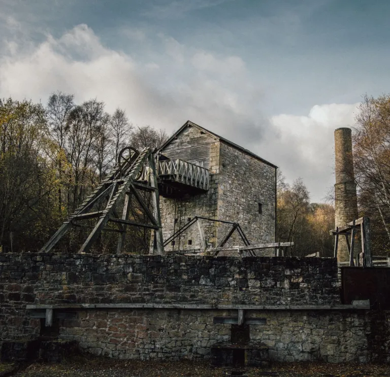 A winding wheel and chimney in a lead mine attraction.