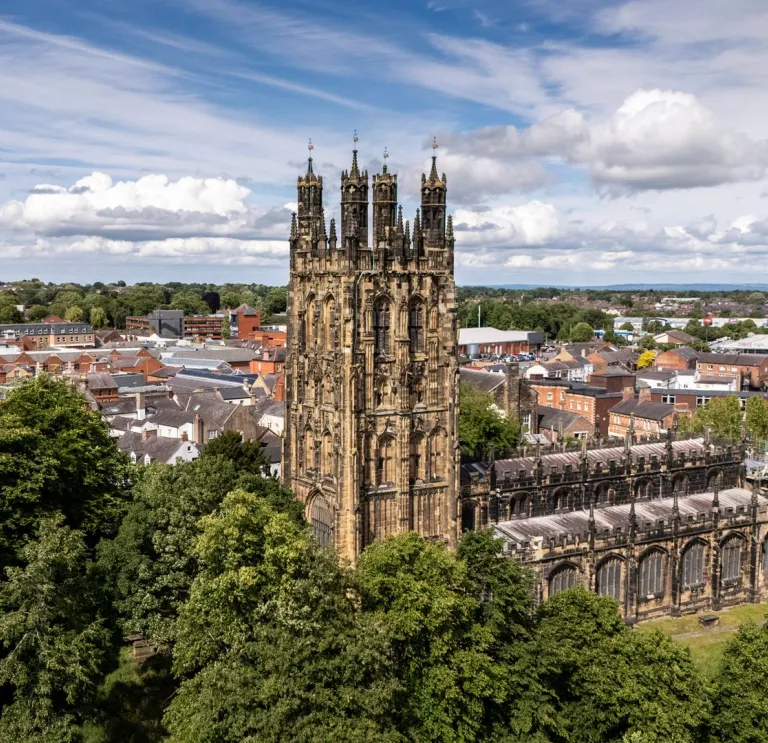 Aerial shot of a medieval church with the city beyond.