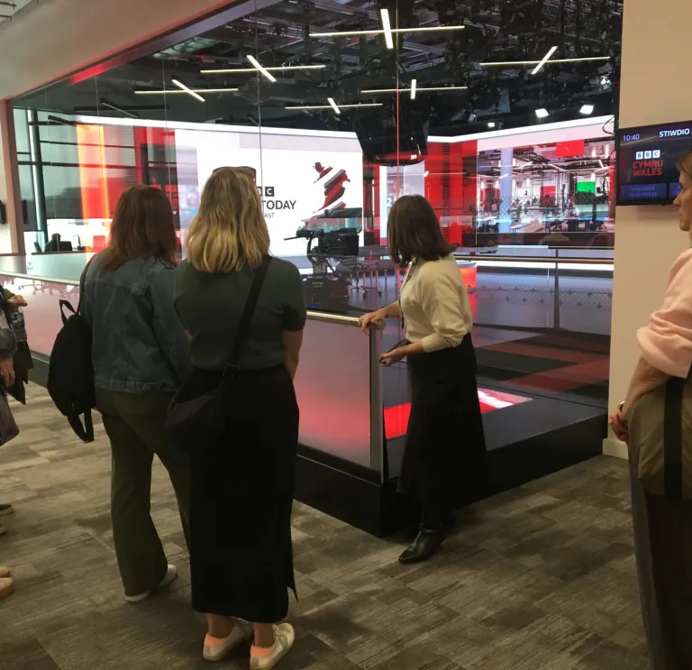 Group on a tour with a guide at a broadcasting studio.