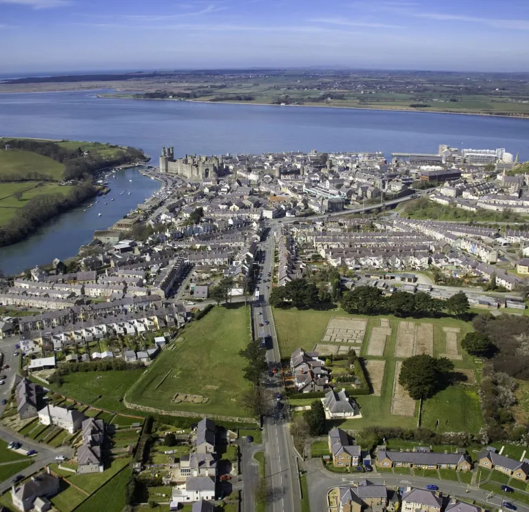 Aerial shot of a town, castle and shoreline.