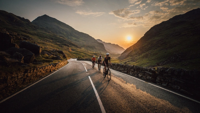 Group of cyclists on a mountain road with the sunsetting beyond.