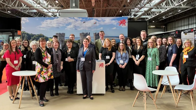 Group of people at a trade show smiling at the camera.