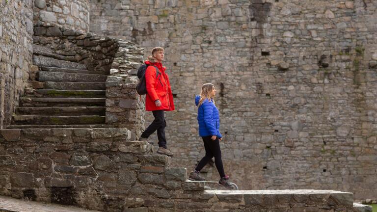 A couple walking down the steps in a castle.