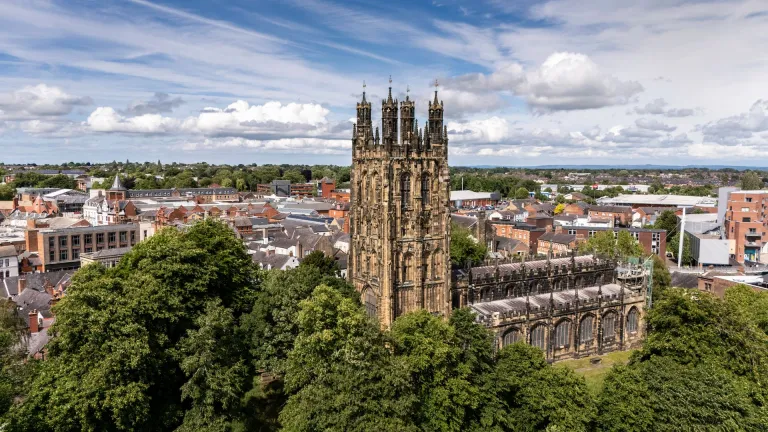 Aerial shot of a medieval church with the city beyond.