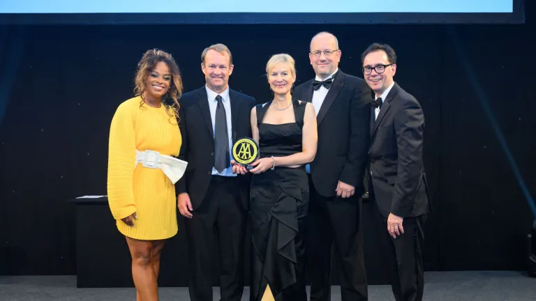 Group of people with an award posing for the camera.