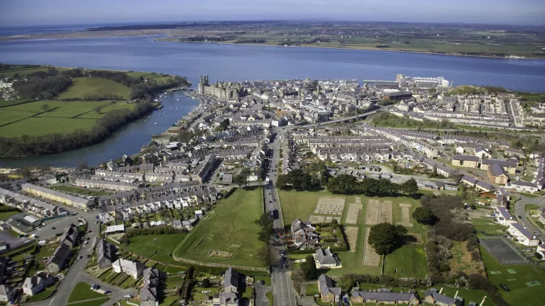 Aerial shot of a town, castle and shoreline.