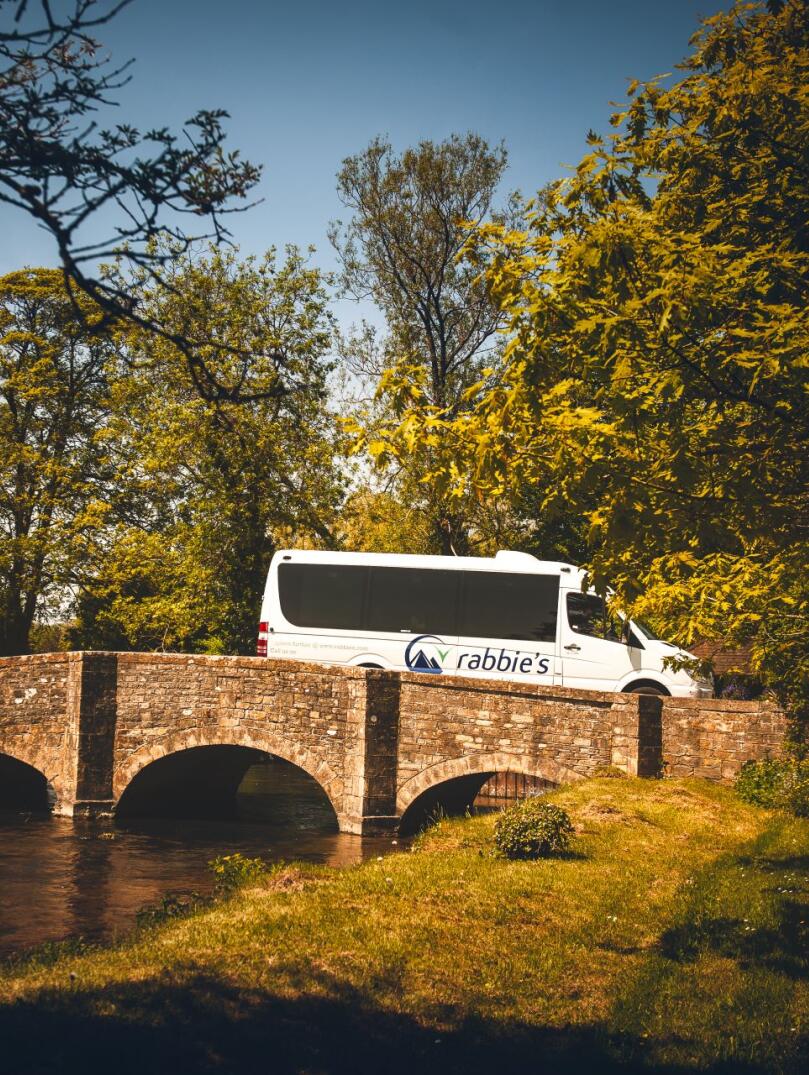 Mini bus going over a bridge with the river flowing underneath