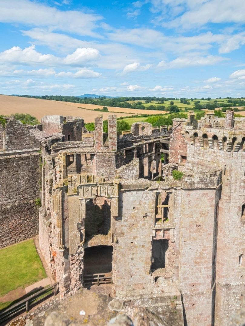 The ruins of a castle with views of the countryside beyond.