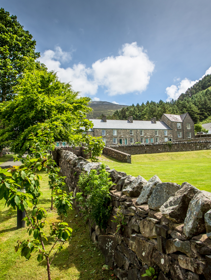 Stone built cottages at Nant Gwrtheyrn looking over the grass square.