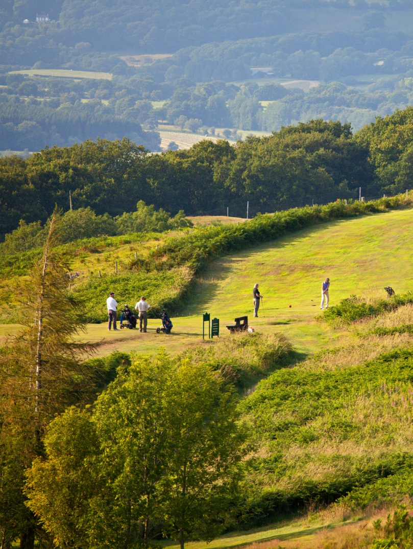 Golfers playing a round with stunning views seen from the height of the golf club.