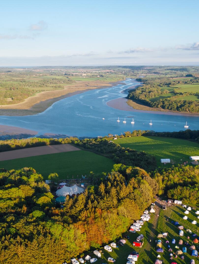 Aerial shot of a festival against an estuary.