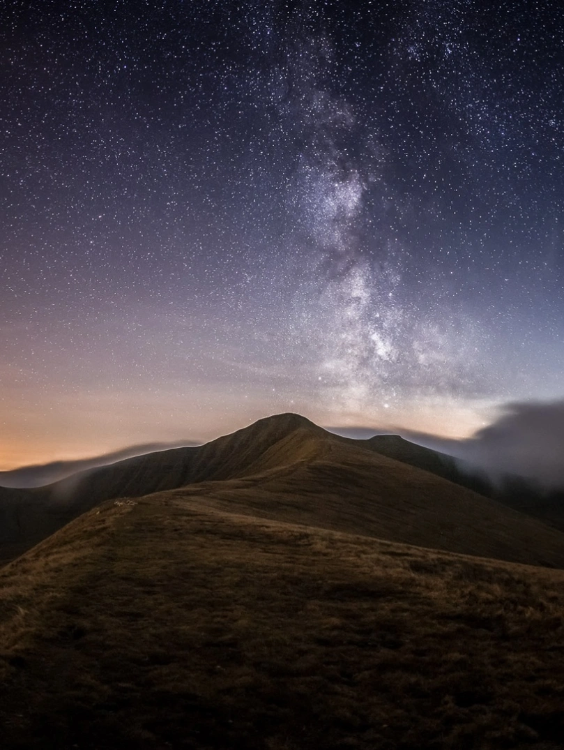 Stars in the night sky with mountains.