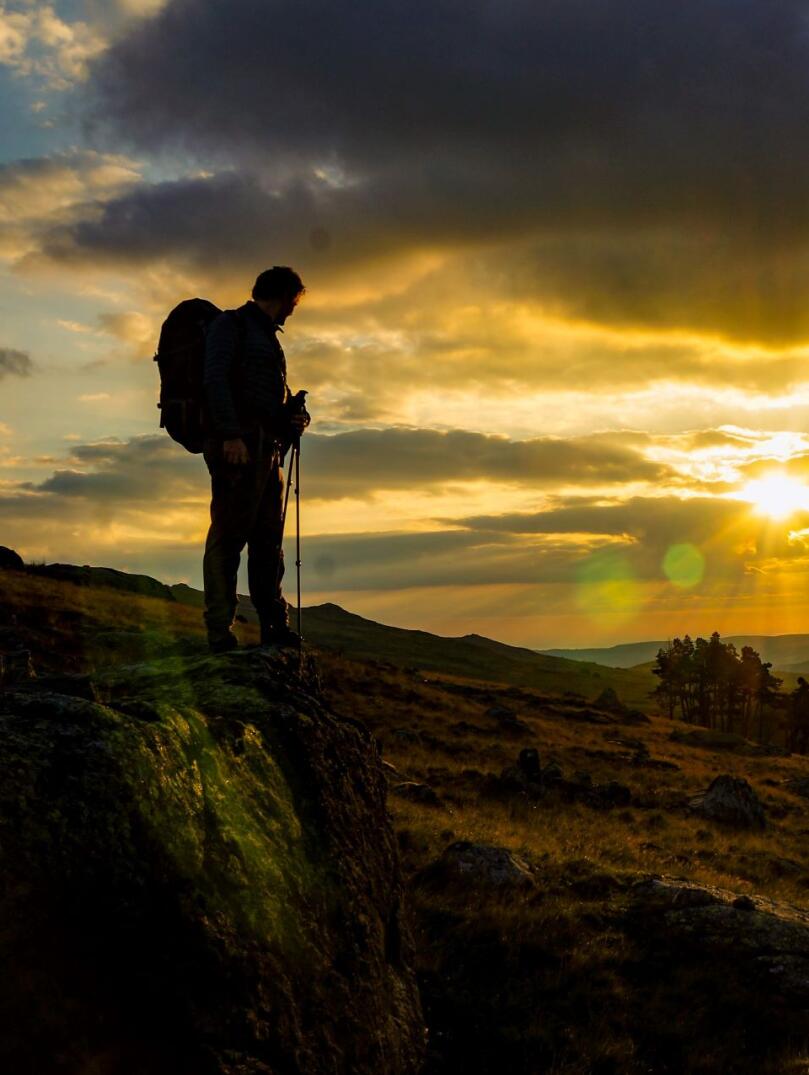 A walker on a mountain watching the sunrise.