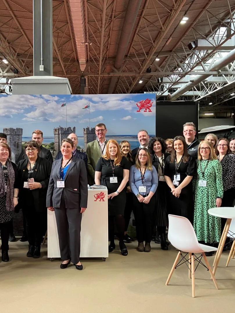 Group of people at a trade show smiling at the camera.