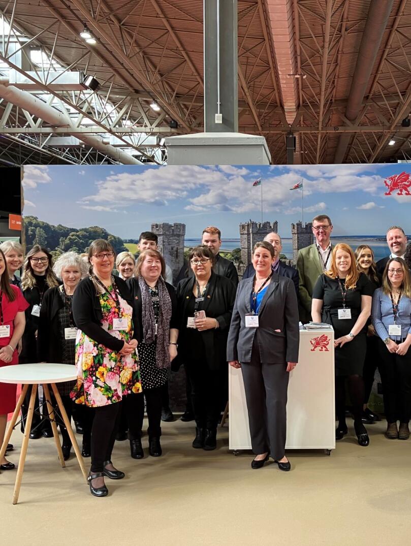 Group of people at a trade show smiling at the camera.