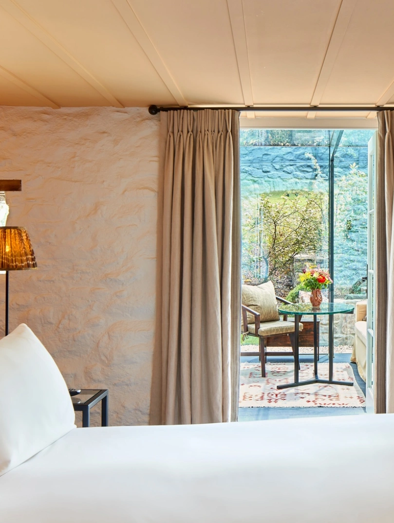 Bedroom suite leading out to a balcony with table and chairs.