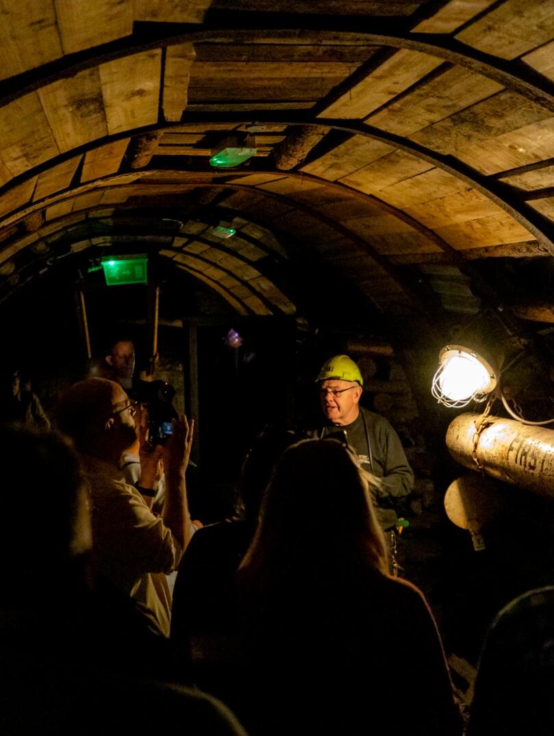 Group of people in an underground mine on an tour with a guide.